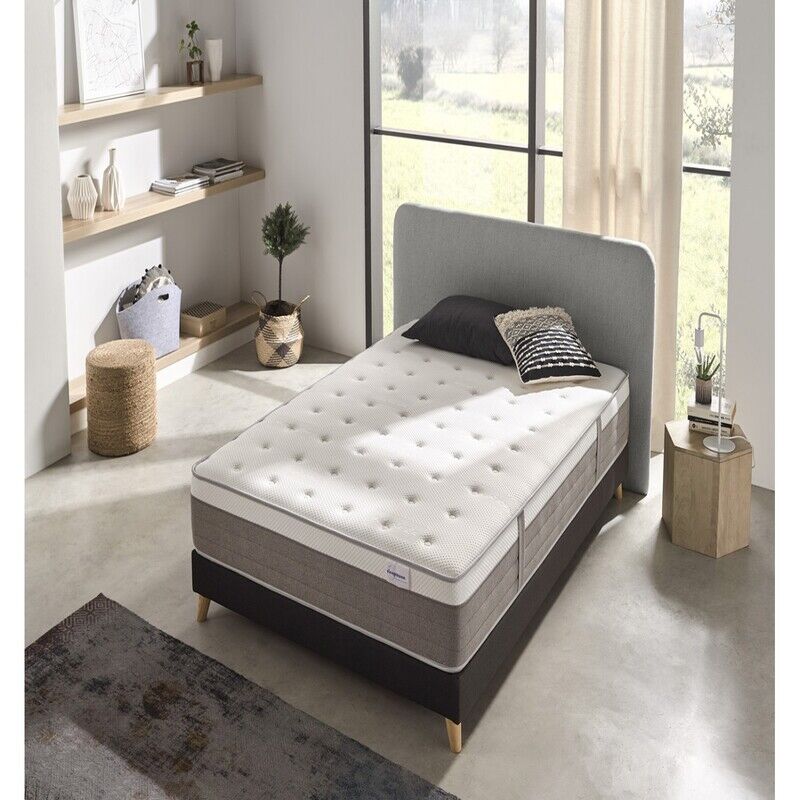 Vista elegante de un colchón premium sobre una base tapizada en un dormitorio moderno. El colchón luce capas acolchadas y tejidos suaves, transmitiendo confort, lujo y calidad superior.